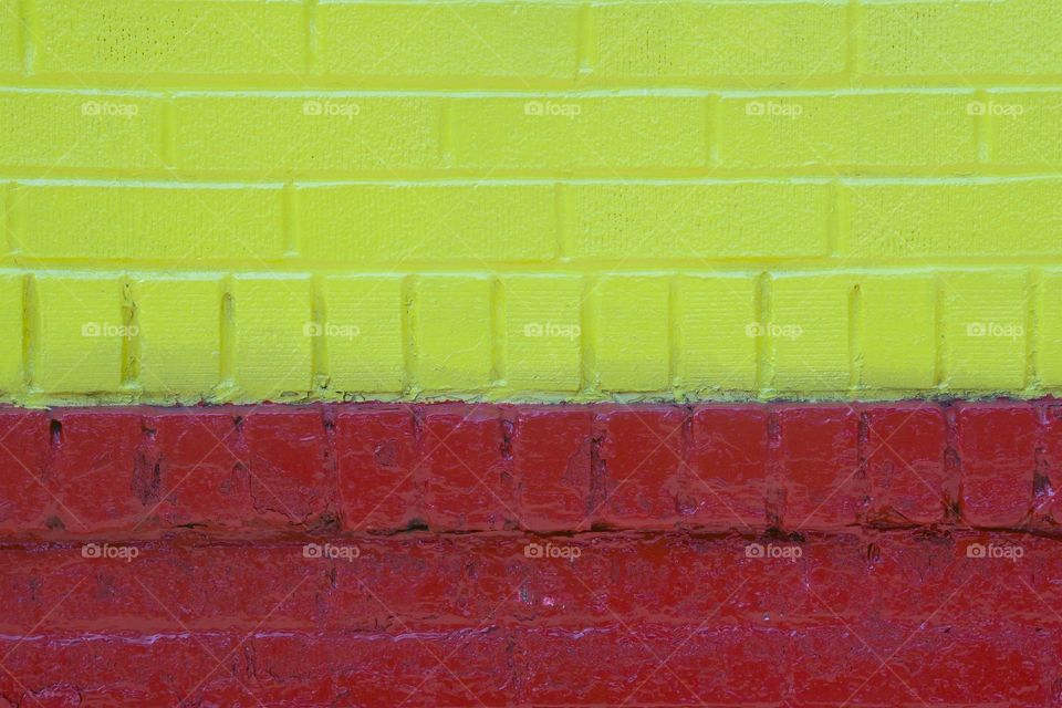 A painted yellow and red brick wall in New York City