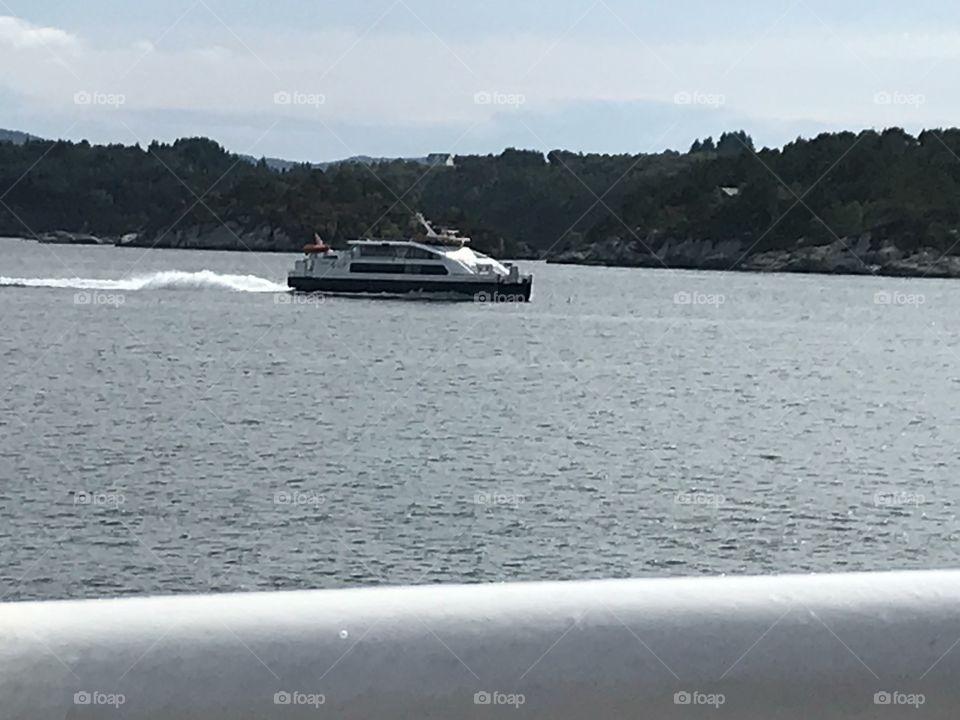 Fast moving ferry cruising over the Ocean at 38 knots. In sunny, warm weather.