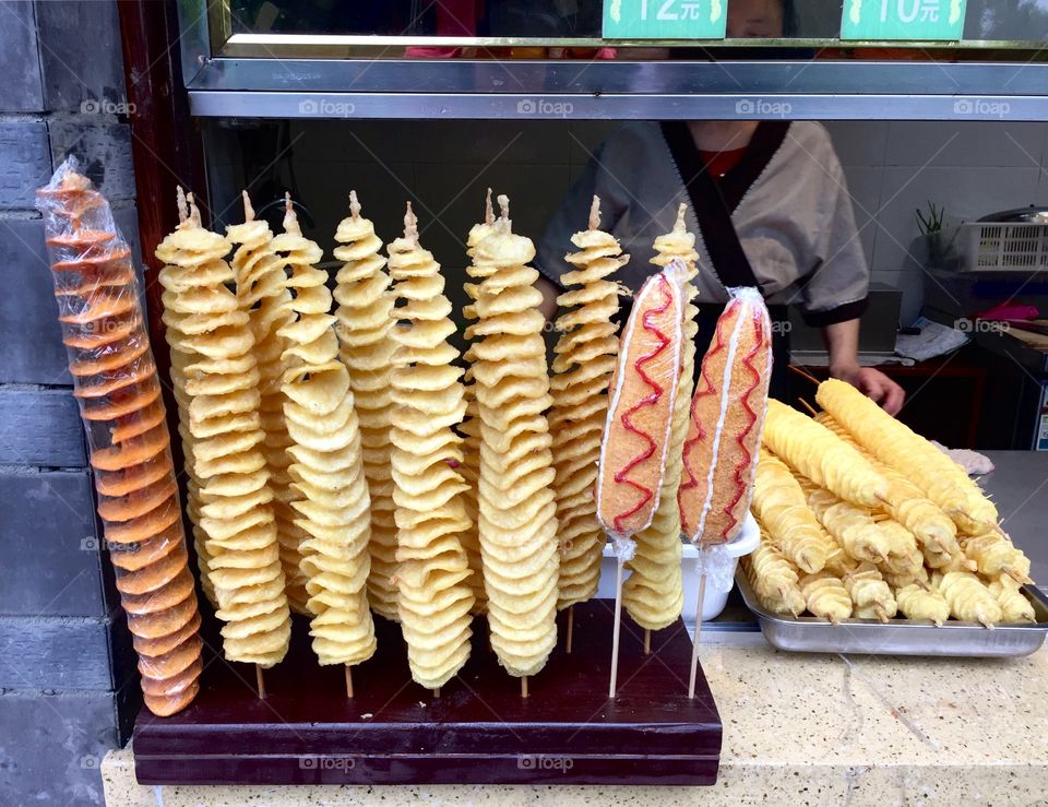 Chips on a long stick. Street food in Chengdu, Sichuan, China

When traveling in Sichuan China, we tried some local food. Some were for tourists so the qualities were not very good; some were too strange for us, but there were always some good tasting foods. Eating like local was a great experience when traveling. We had no stomach issues after trying some of these street foods, but were not brave enough to try any cooked insects. 
