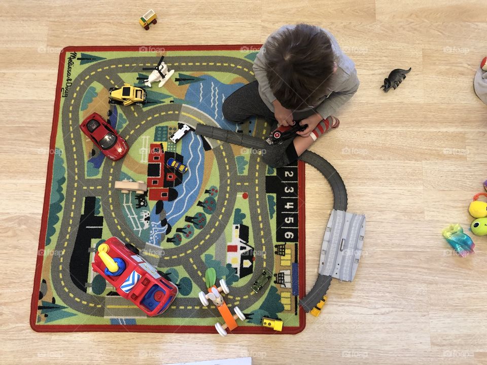 Child playing on the floor with cars II