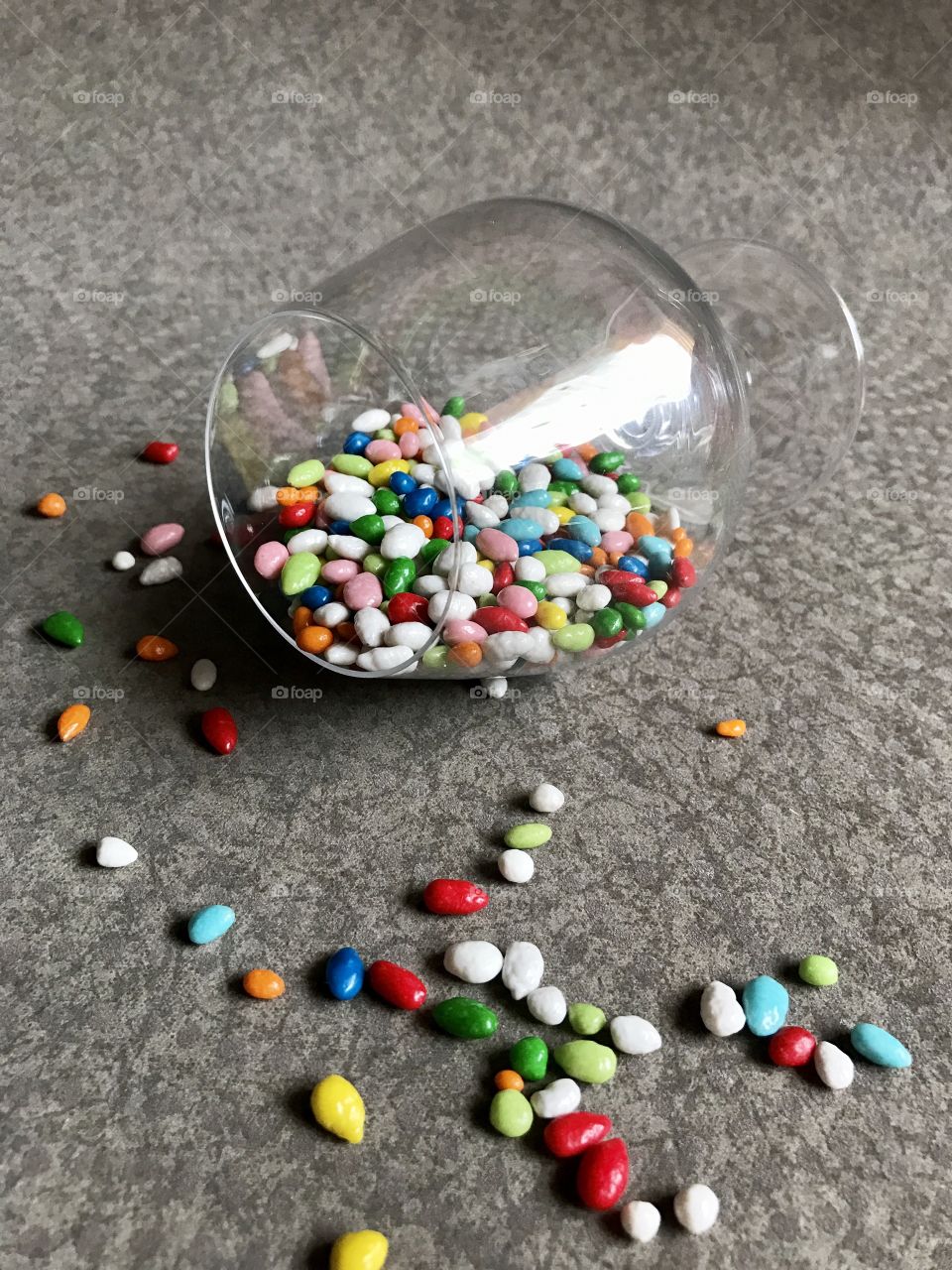 Multicolor candy in a glass on grey background 