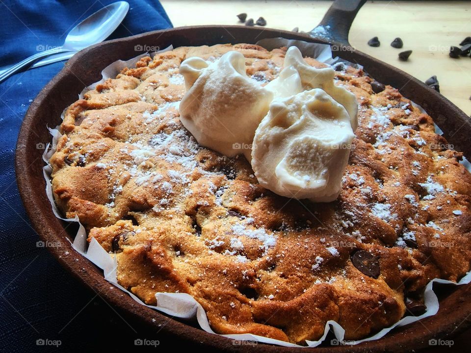 Homemade peanut butter chocolate chip skillet cookie and vanilla ice cream.