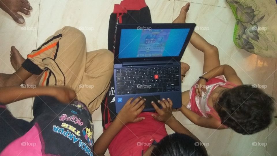 child operating laptop playing games