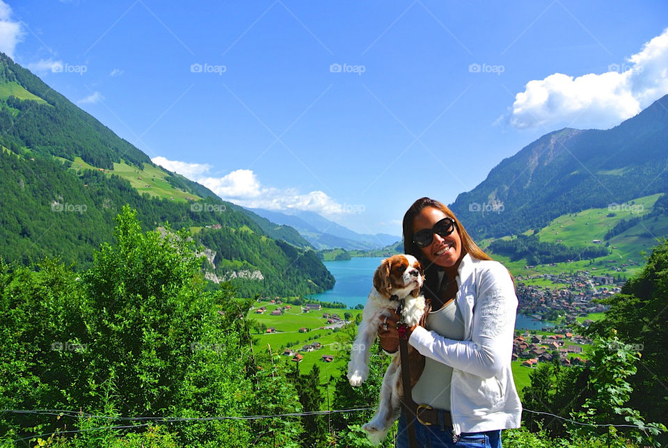 Portrait of woman with her dog in front of village