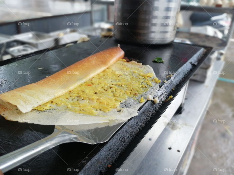 A dosa is a cooked flat thin layered rice batter, originating from the South India, made from a fermented batter.Its main ingredients are rice and black gram ground together in a fine, smooth batter with a dash of salt.