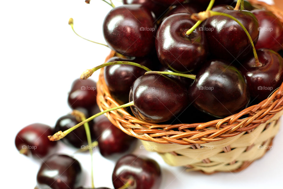 Cherry in basket against white backgrounds