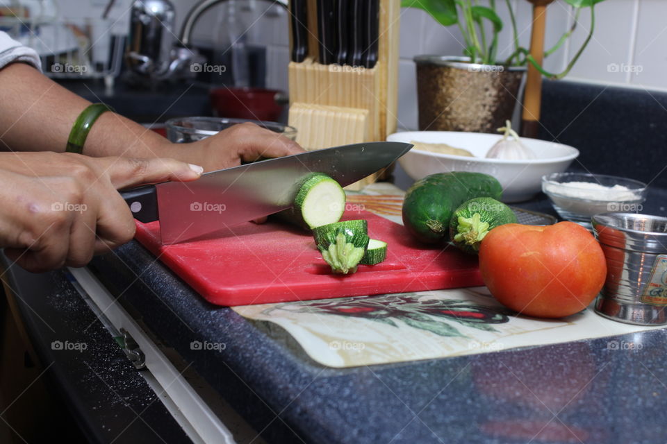 Preparing food in kitchen using vegetables and kitchen knife