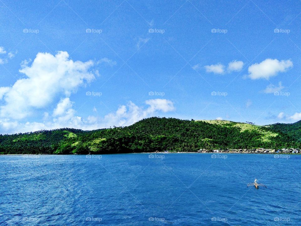 Blue skies with deep blue sea at the greener side of nature.