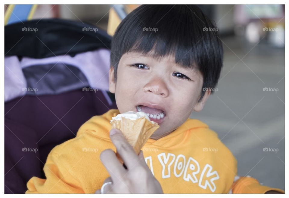 Crying Japanese boy having ice cream