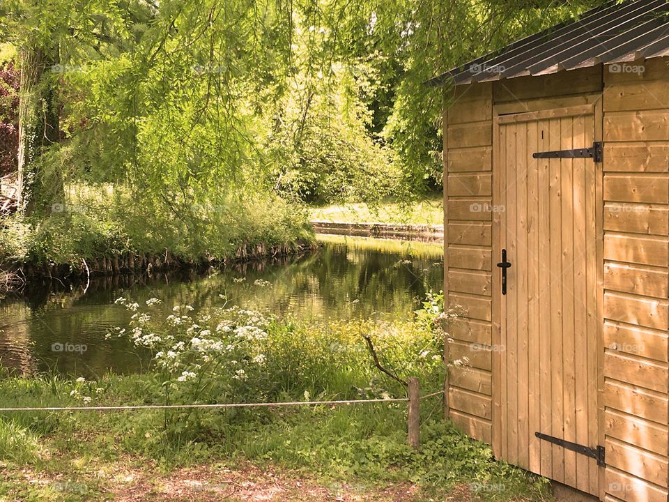 Wooden cottage door along thin river