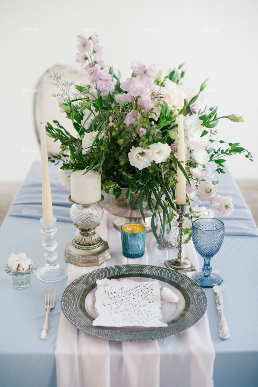 Silver candlestick and other elements of festive table wedding centerpieces decorations.