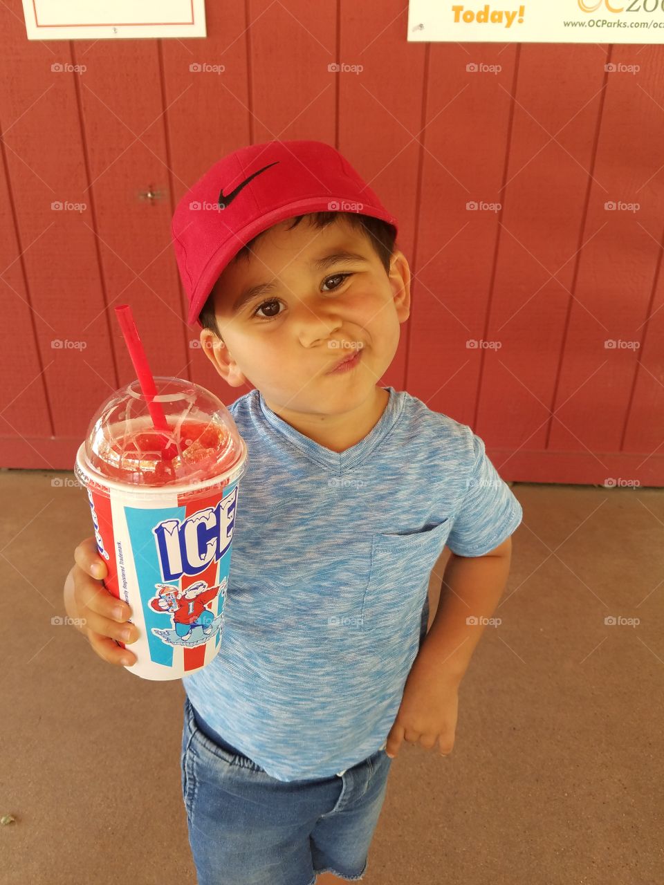 Crazy boy holding drink glass with straw