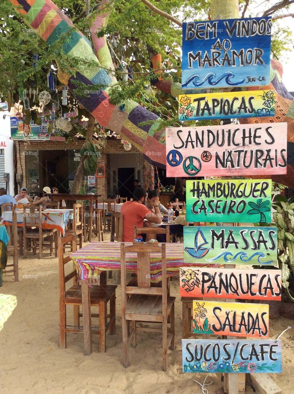 Colorful hand painted wooden signs welcoming tourists to restaurant with their general menu