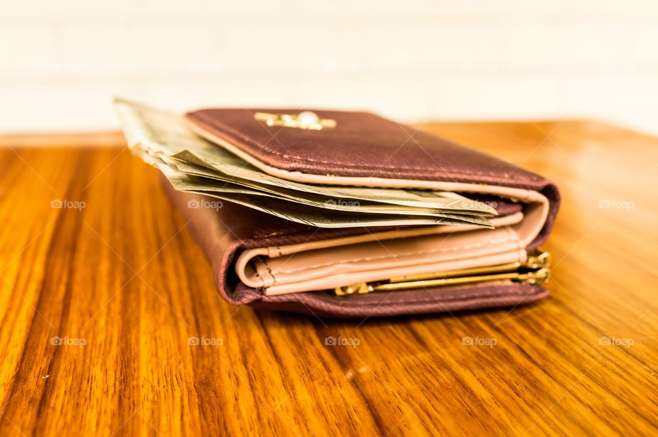 Indian five hundred (500) rupee cash note in brown color wallet leather purse on a wooden table. Business finance economy concept. Side angel view extreme close up with copy space room for text left in front