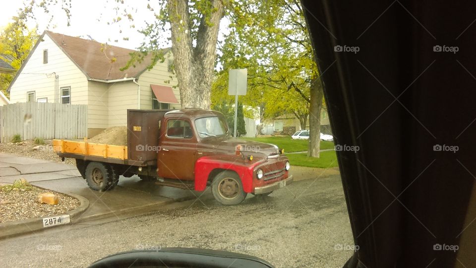 old truck backinging in to dump gravel