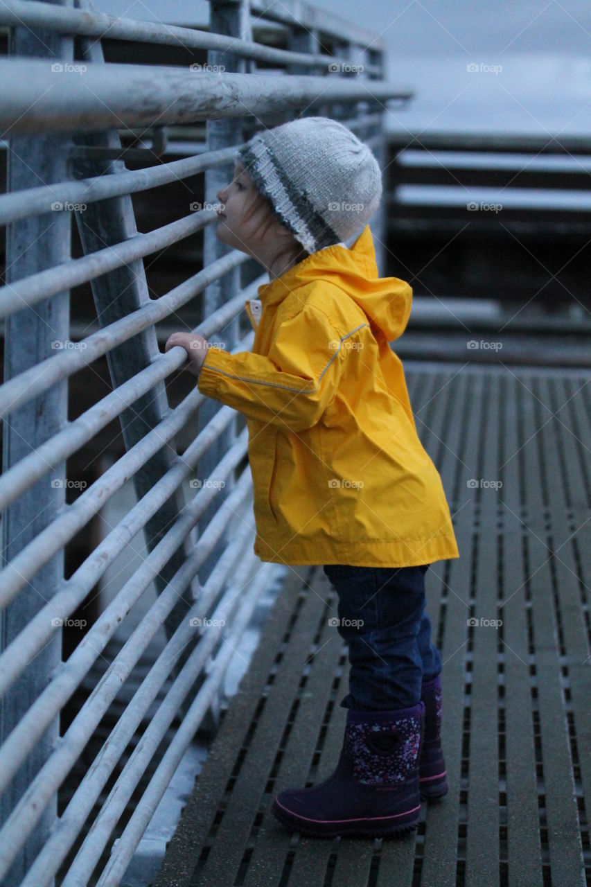Little girl standing near railing