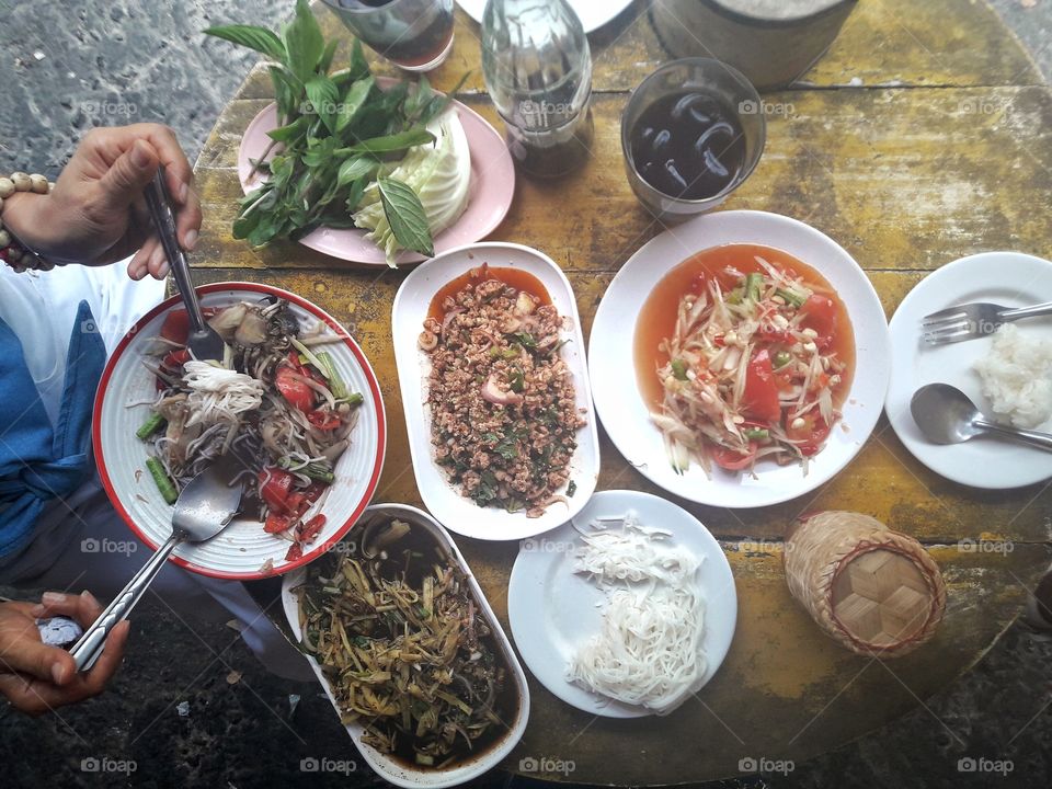 People eating Thai food.  There is a famous delicious papaya salad, etc. and other menus that are equally delicious.  Delicious Thai food. Food and drink.