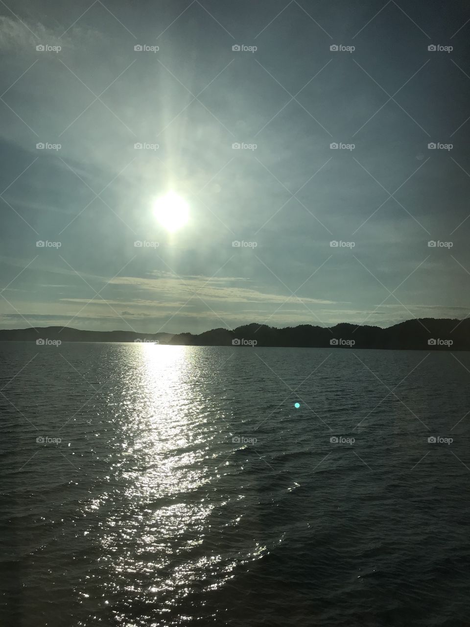 The sun over the sea. The sun makes a light reflecting in the water and that looks very good.