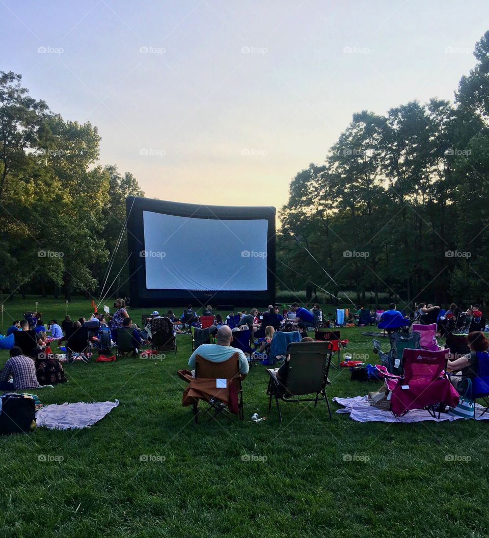 Outdoor summer movie night at sunset on a grassy lawn 