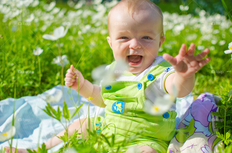 Small baby sitting in flower field