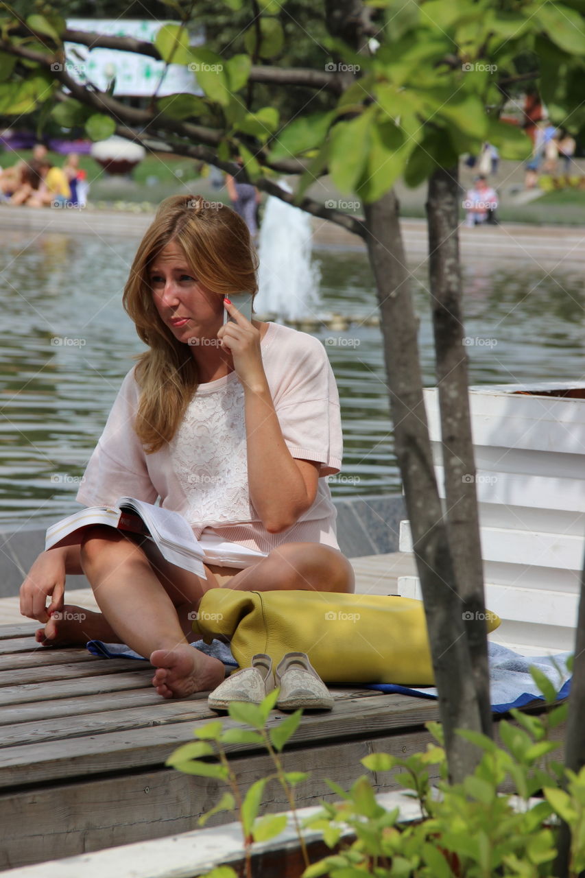 девушка разговаривающая по телефону в парке