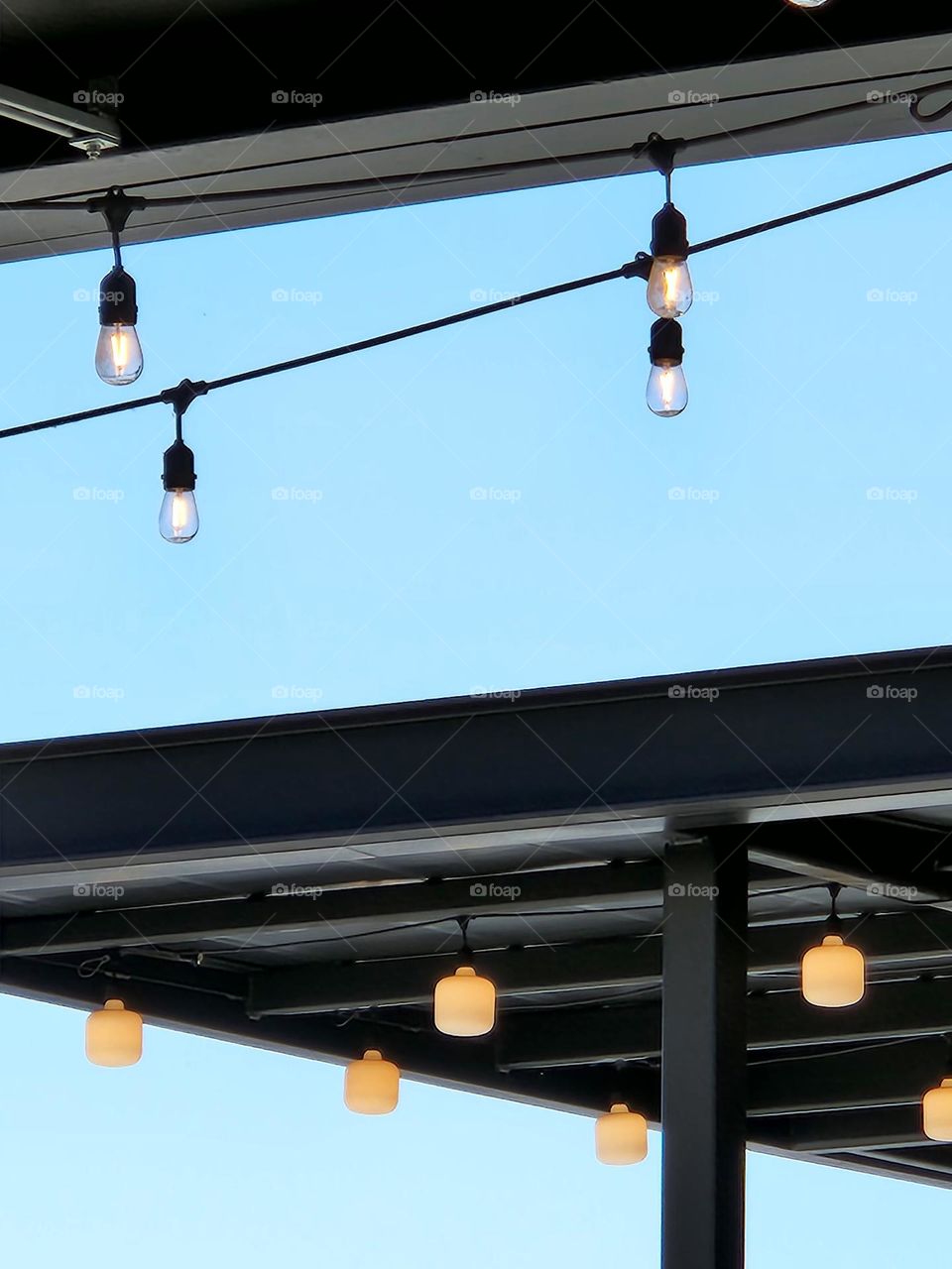 strings of outdoor lights on restaurant roofs during the daytime