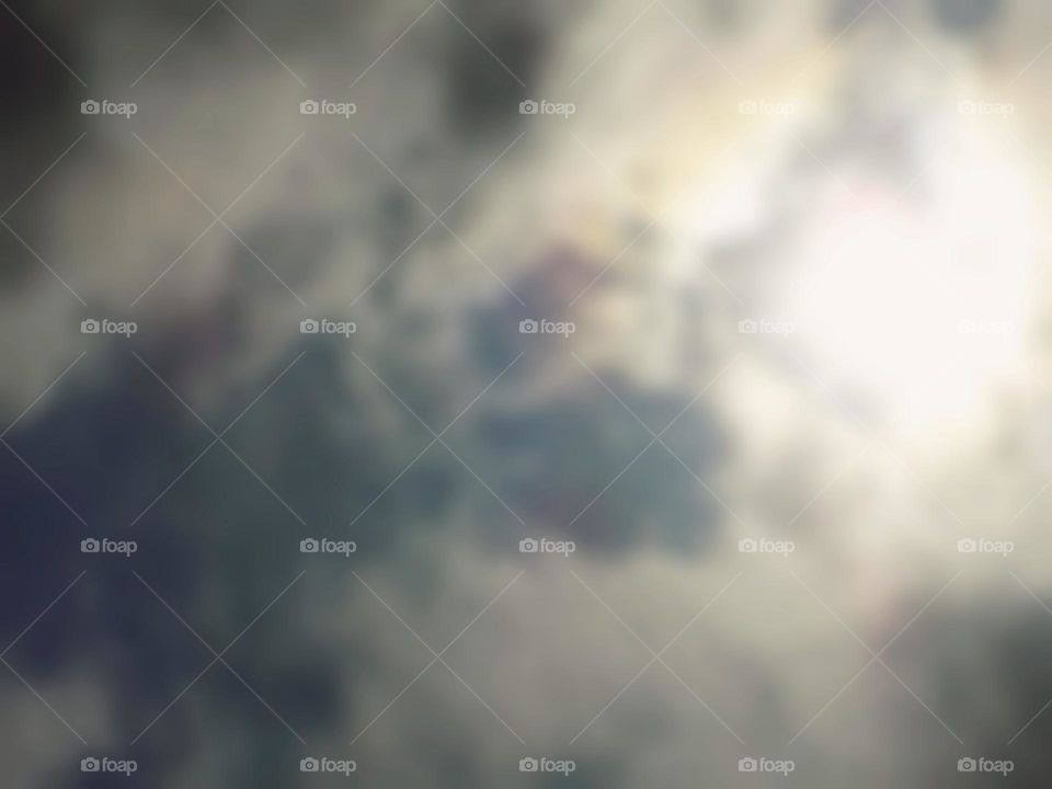 Blurry photo of the sun in the sky at noon