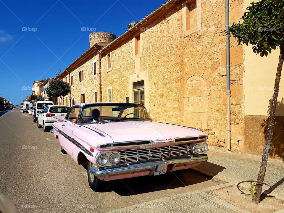 a pink chevrolet classic car / oldtimer on the streets of Mallorca. it seems if time has stopped