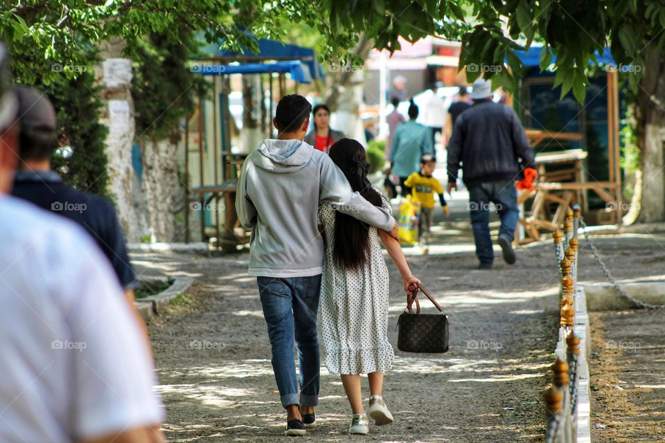 summer walk of a couple in love through the city streets sunny weather