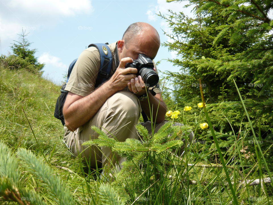 Biologist man photographing plants from camera