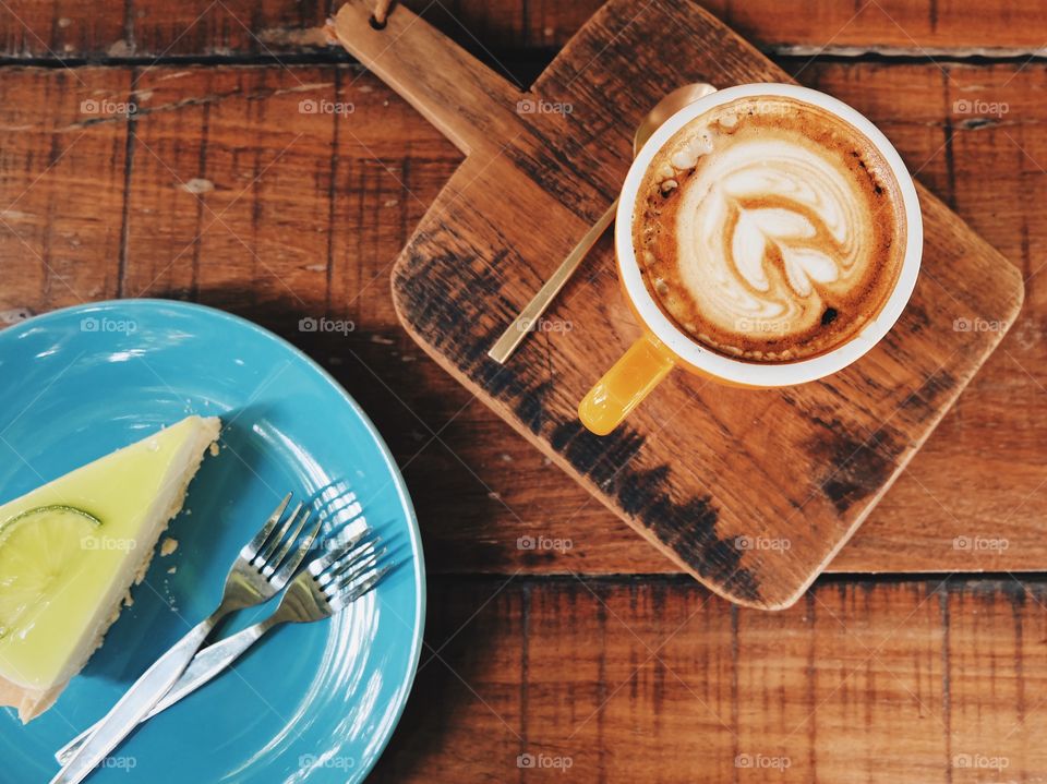 Coffee cup with slice cake on wooden table