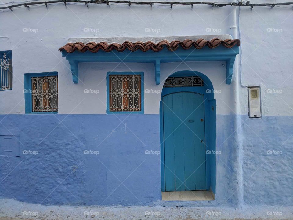 Adorable Blue Door and Home with Ornate Windows in Chefchaouen (the Blue City) in Morocco