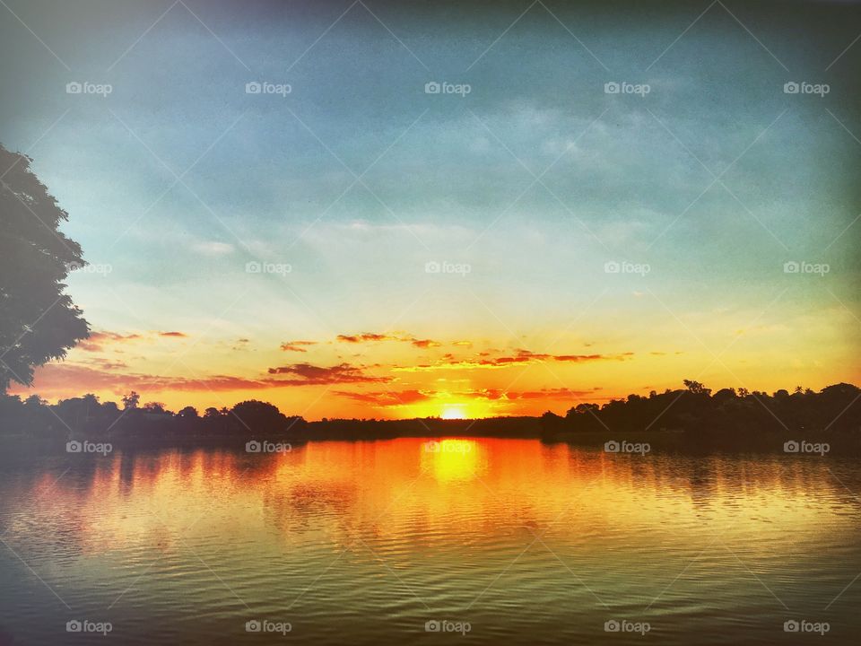 Calm lake against dramatic sky