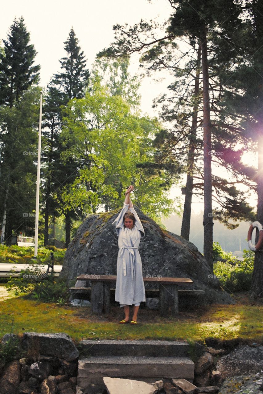 Sunrise gymnastics in Nordic forest by glassy lake in Sweden