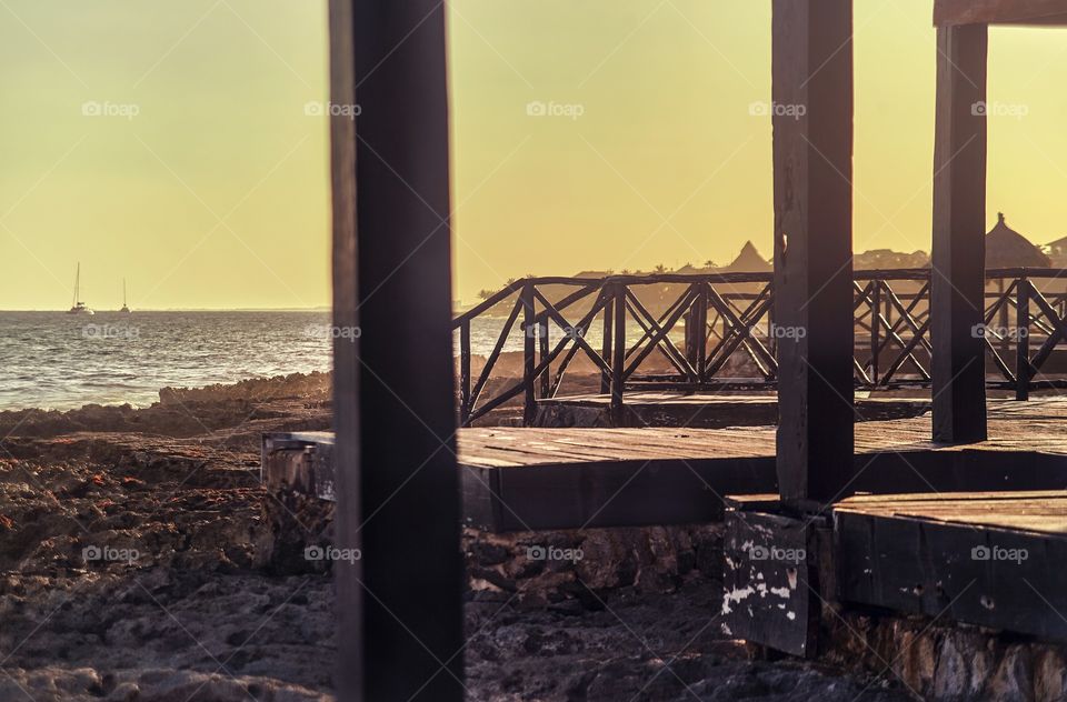 Detail of a wooden pier overlooking the beautiful beach of Puerto Aventuras in mexico in the Mayan Riviera at sunset.