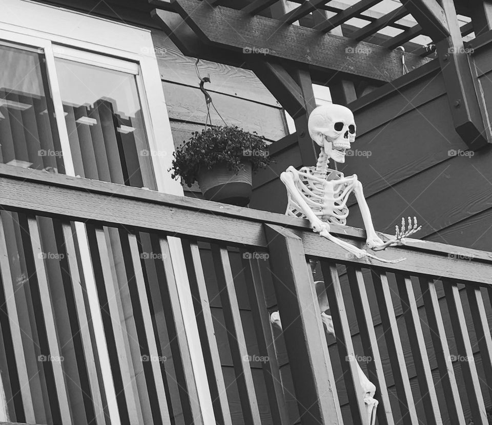 black and white view of a skeleton decoration on an apartment deck in Oregon looking pensive