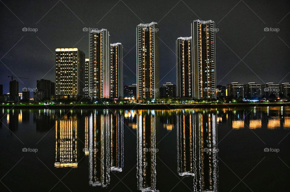 Beautiful reflection of high buildings in water at evening time 