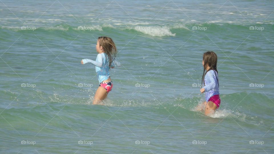 Watch me jump over that humongous wave, little sister!