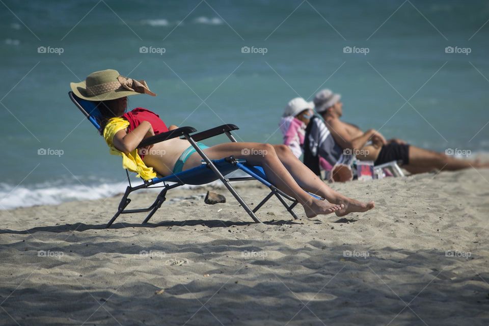 People enjoying sun on the sandy beach