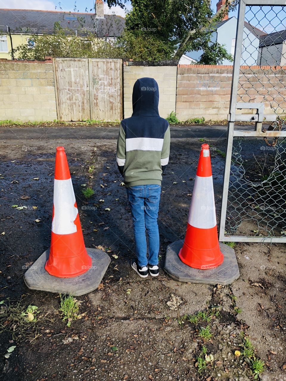 Young boy standing in between two cones 