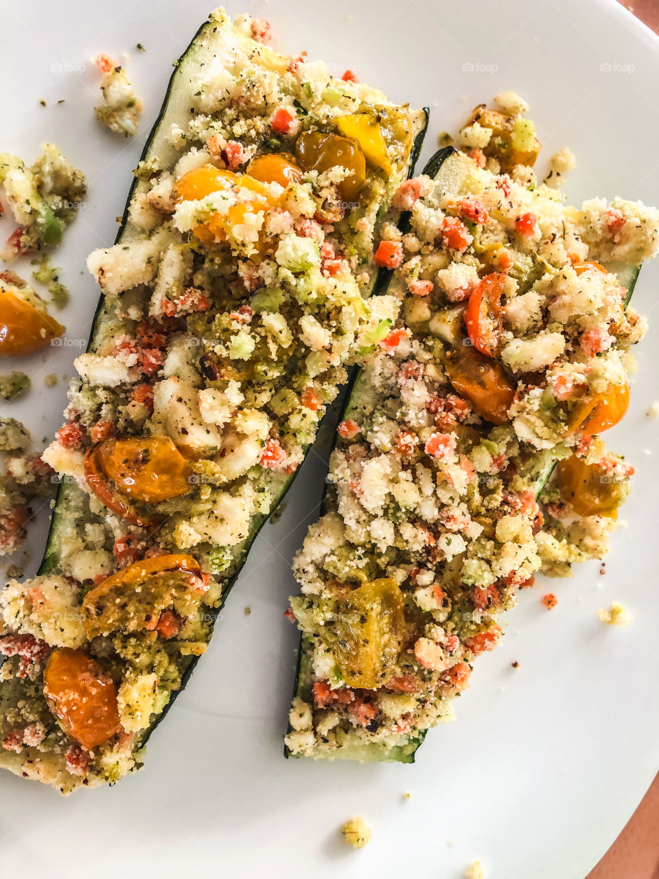 Homegrown courgette, stuffed and sprinkled with feta cheese on white plate