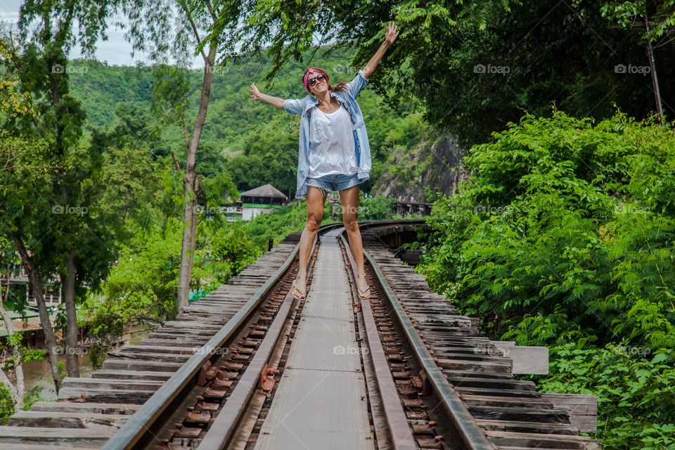 Happy woman standing on empty rail track