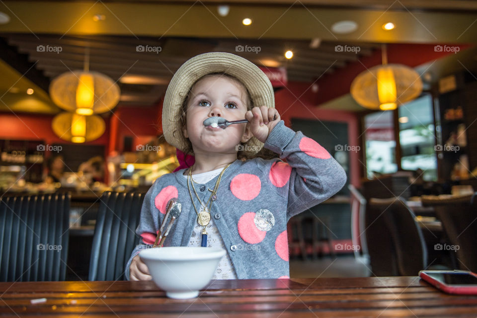 Toddler eating food in restaurant