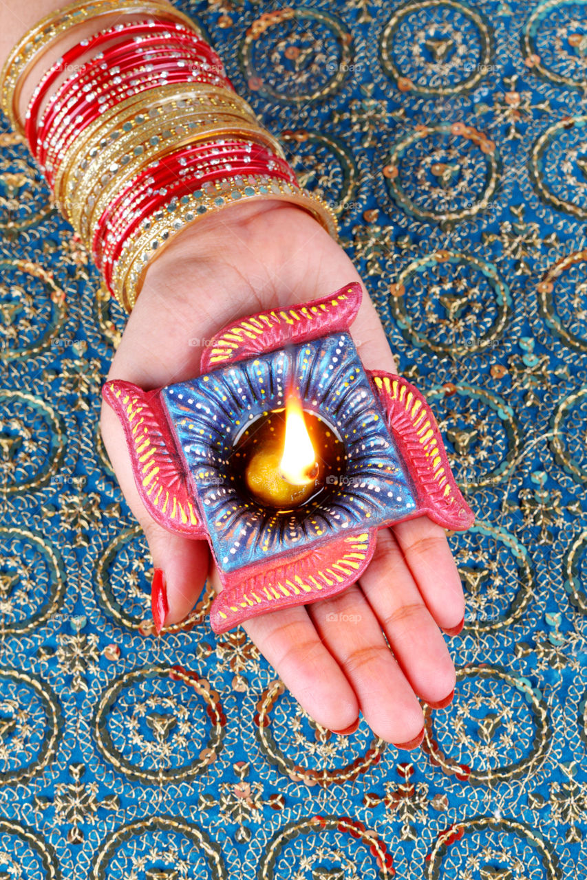 Swastika shaped Diwali diya in a female hand