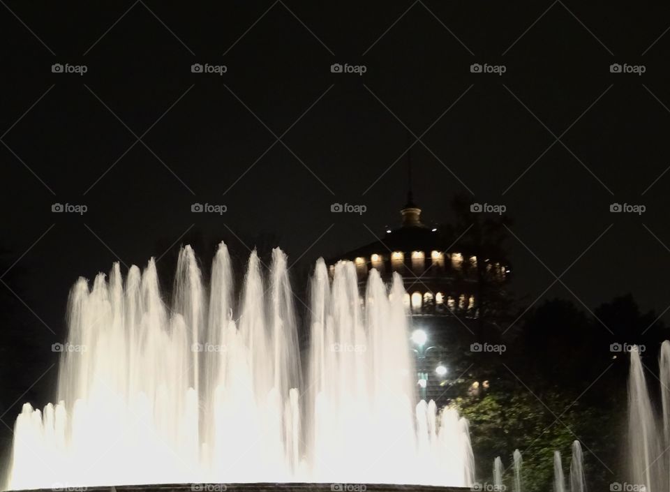 Water fountain in front of a castel at night 
