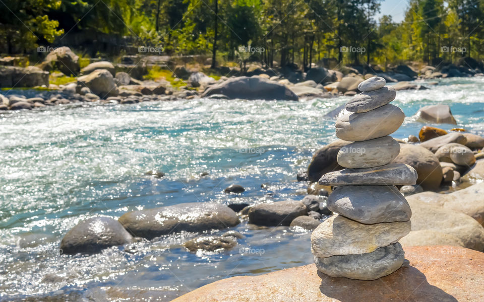 Balance and wellness retro spa concept, inspiration, zen-like and wellbeing tranquil composition. Close-up of white pebbles stack balanced stones on the rocky shore over near river side.