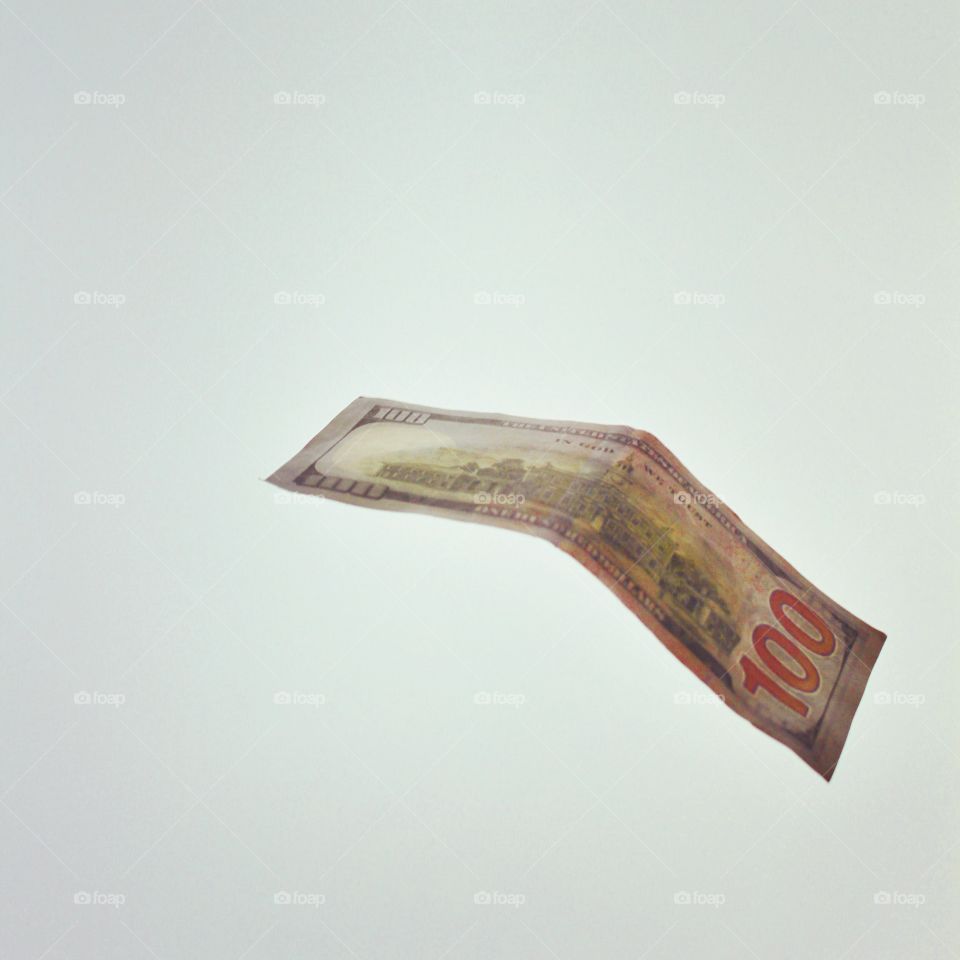 Floating money, hundred dollar bill against a cloudy sky!