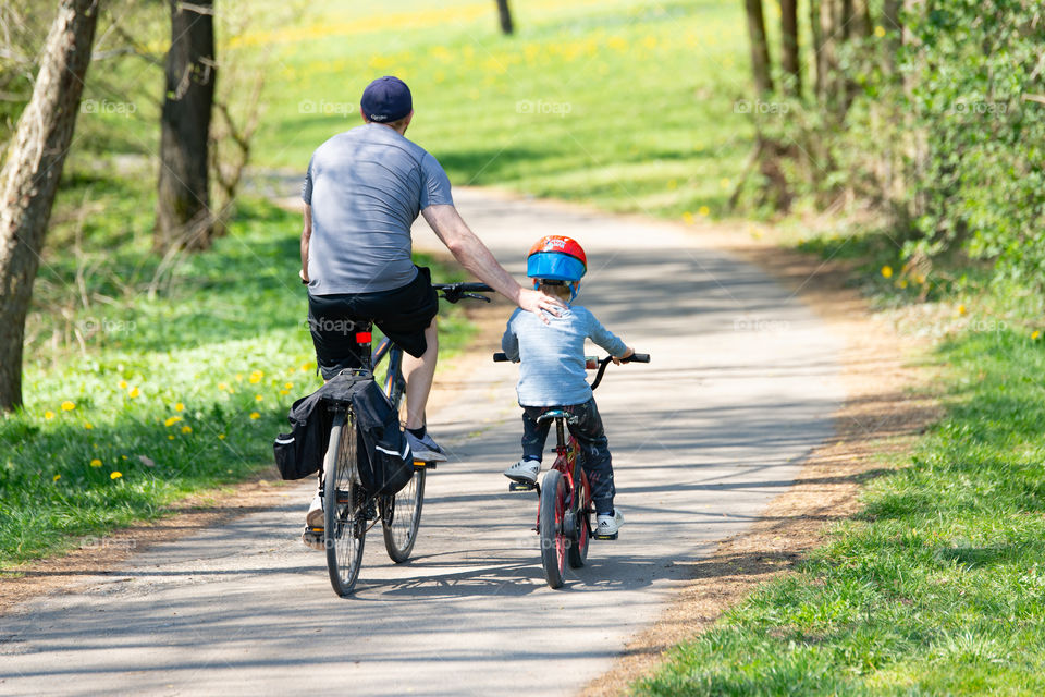 father and little son on a bike tour in springtime