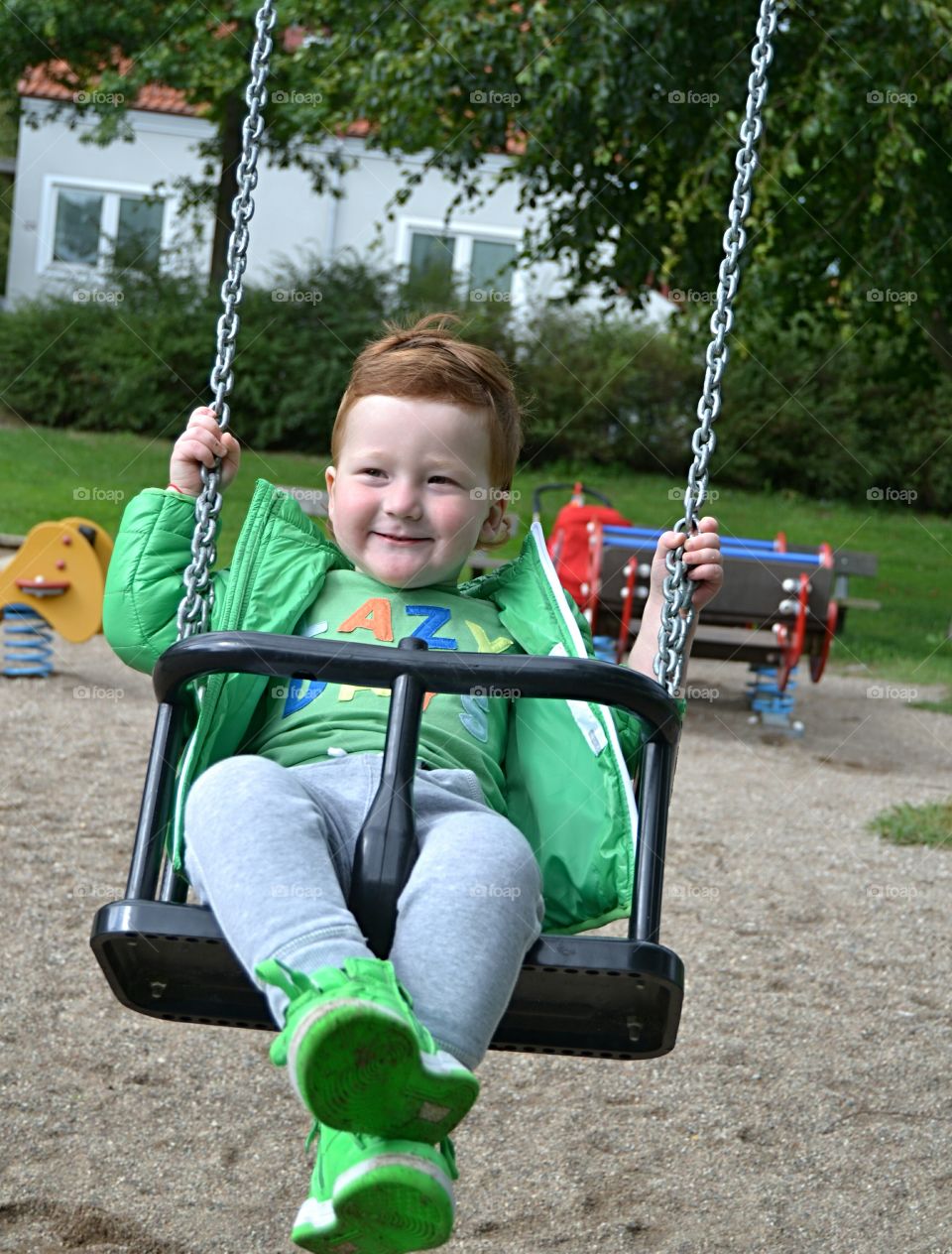 Portrait of boy hanging on a swing