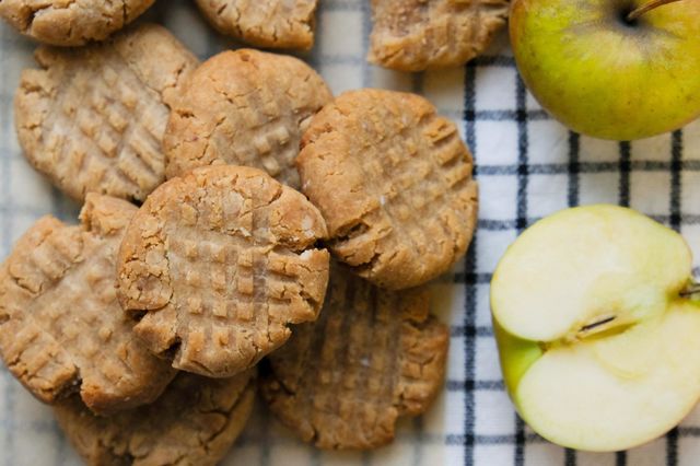 Close up of American peanut butter cookies with cut apple on the checkered napkin